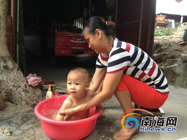 　　漁嫂楊麗正在用剛投入使用的海水淡化廠生産的淡水給兒子洗澡。南海網記者高鵬攝