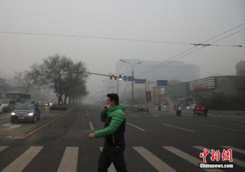 資料圖：一名戴著口罩的行人走在北京街頭。中新社記者 張浩 攝