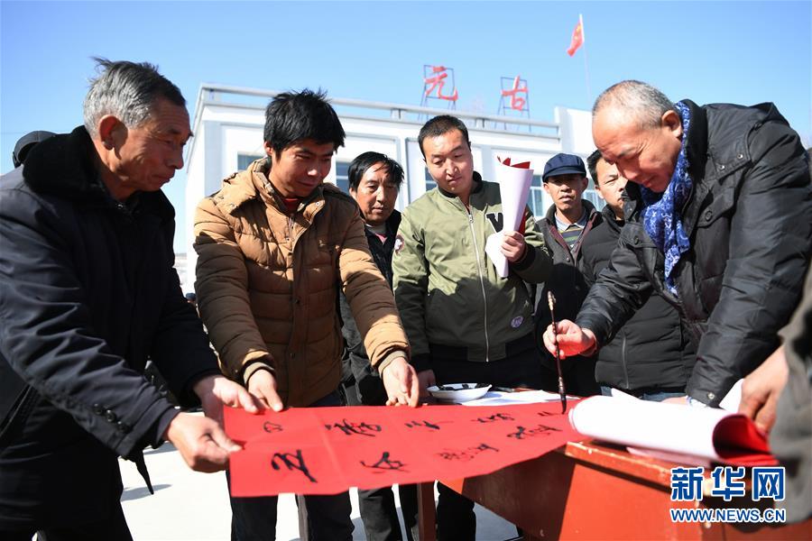 2月11日，甘肅省定西市渭源縣元古堆村村民閆霞亮（左二）在村文化廣場參加寫春聯、送春聯活動。
