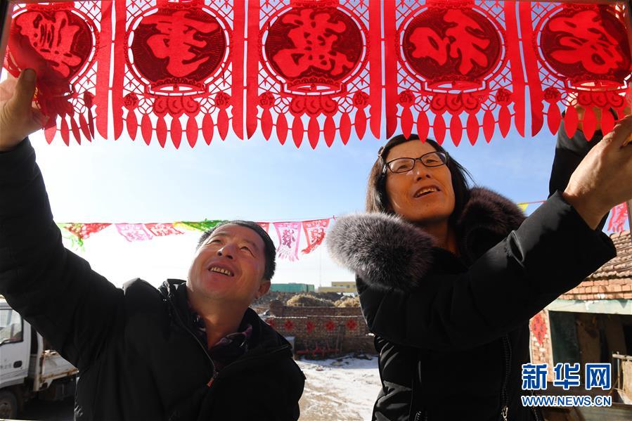 　　2月9日，在河北省張北縣小二台鎮德勝村，徐海成（左）和妻子裴秀平在家中佈置春節裝飾。
