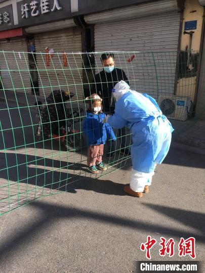 1月8日一早，醫療隊護士李凱的丈夫特地帶著4歲的兒子趕來，多日不見的一家三口隔著防護網“團聚”了一分鐘。圖片由陸軍軍醫大學士官學校附屬醫院提供