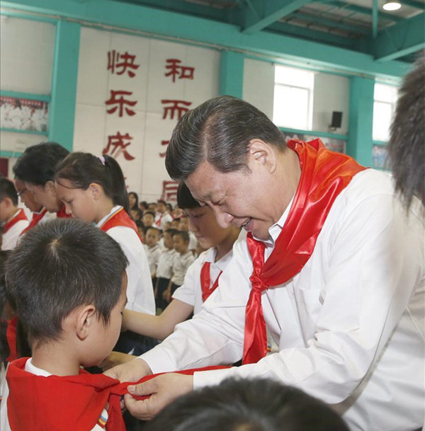 2014年5月30日，在北京市海澱區民族小學的少先隊入隊儀式上，習近平為新少先隊員繫上紅領巾。