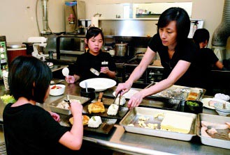 蔡颖卿带领小厨师们在厨房工作,让他们了解餐厅提供的美味料理是怎