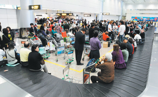 桃園機場昨天傍晚突然跳電，第二航廈行李處理系統停擺，上千名旅客在行李轉盤處等候。圖片來源：臺灣《聯合報》
