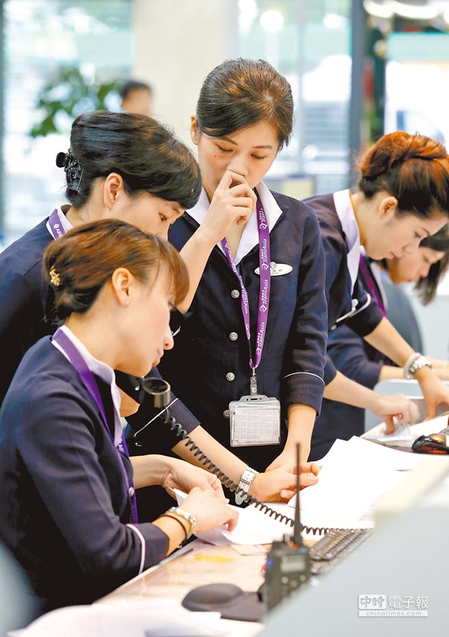 空難重創復興航空公司形象及員工士氣，松山機場的地勤櫃檯人員24日面色凝重，為旅客辦理登機報到手續。