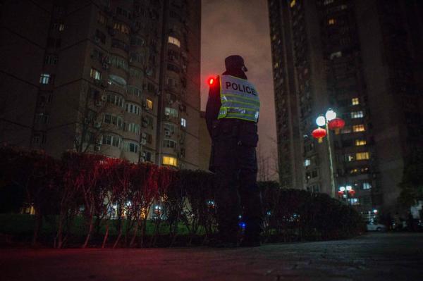 2月7日，除夕夜，上海靜安區，一位民警在小區內執勤。據了解，為了做好煙花爆竹禁放管控工作，這個規模中等的小區內配備有16位民警和68位平安志願者。 澎湃新聞記者 楊深來 圖