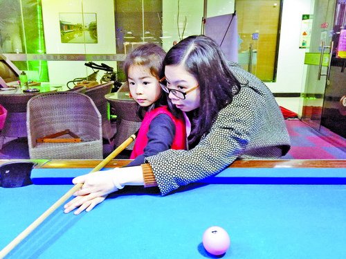 張毅琳在教女兒打桌球。