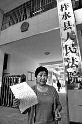 昨日上午11時許，柯長桂拿著判決書站在柞水縣人民法院門外
