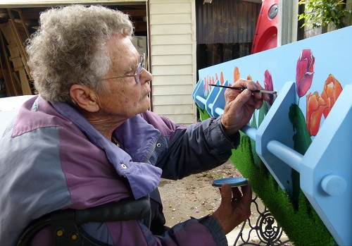 一名老人正在為自己的棺材繪製圖案。