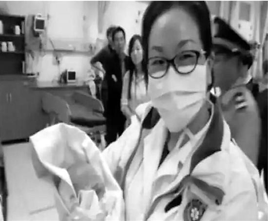 急救人員抱著搶救成功的女嬰(視頻截圖)。