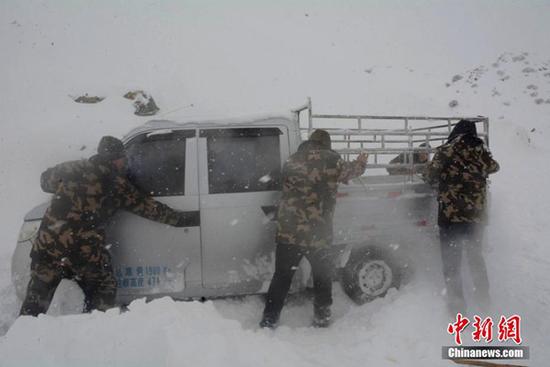 12日,新疆阿勒泰邊防官兵在救援被困車輛。(圖片來源:中新網)