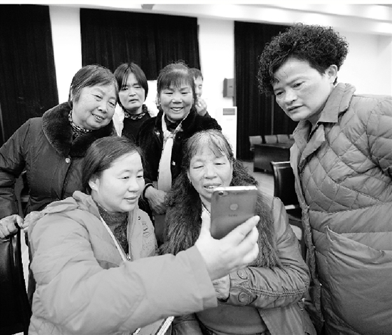趙玲巧（前左）如今也已當外婆，拿出手機跟孩子們視頻聊天。