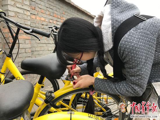  李冬雨在北京街頭為被劃掉多位數字的共用單車補牌。中國青年報�中青線上記者 李想/攝
