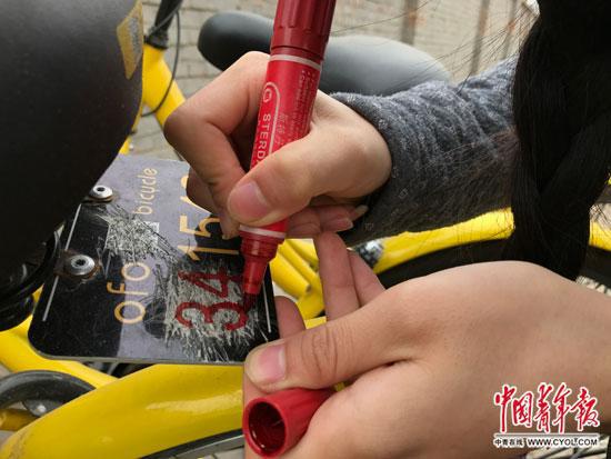  李冬雨正在為共用單車補車牌。中國青年報�中青線上記者 李想/攝
