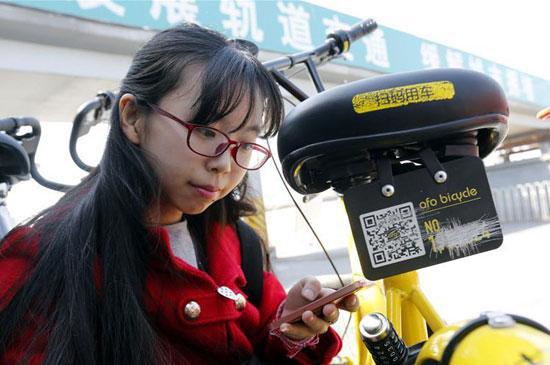 李冬雨在北京街頭為被劃掉多位數字的共用單車補牌。新華社記者 張玉薇/攝