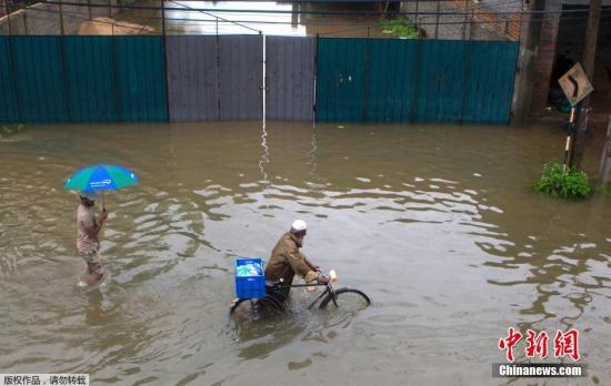 當地時間5月16日，斯里蘭卡科倫坡遭遇暴雨引發洪水淹沒街道，當地民眾水中出行。