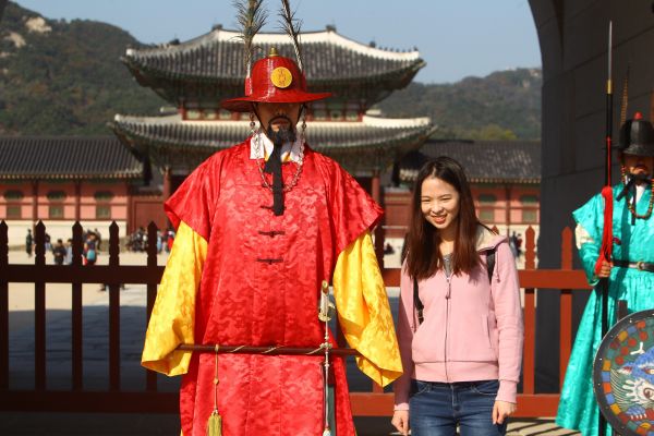 在韓國首爾景福宮外，中國遊客與韓國守城門將合影。