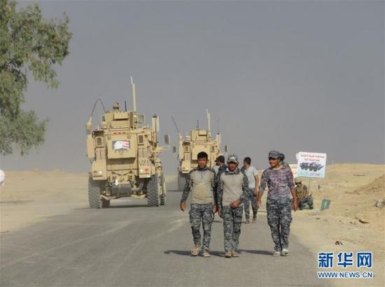 10月18日，伊拉克政府軍士兵行進在摩蘇爾市南部蓋亞拉鎮前線。新華社發（雅茲爾攝）