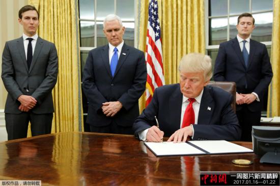 當地時間1月20日，新上任的美國總統特朗普坐在白宮橢圓形辦公室內，簽署下他任期內的第一批行政命令。在特朗普身後，站立著他的女婿兼總統高級顧問賈裏德�庫什納、副總統彭斯，以及員工秘書長Rob Porter。