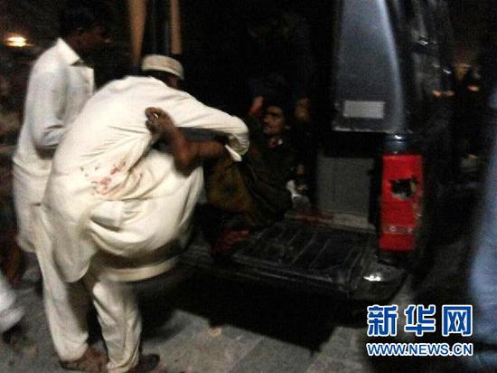 2月16日，在巴基斯坦信德省塞赫萬地區，民眾在抬運傷者。新華社發。