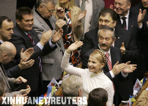 12月18日，烏克蘭議會批准季莫申科聯盟領導人季莫申科出任政府總理。這是季莫申科（著白上衣者）當天在首都基輔舉行的議會表決後向人們揮手致意。 新華社/路透