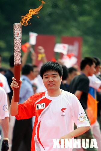 　5月30日，奧運火炬手丁俊暉手持火炬傳遞。當日，北京奧運聖火在安徽績溪傳遞。     新華社記者邢廣利攝