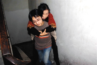  2005年11月13日，浙江臨安，下課的劉霆背著母親回到出租房。1999年，陸永敏被確診患有尿毒症，父親離家出走。劉霆上大學後，邊求學邊照顧母親。受訪者供圖