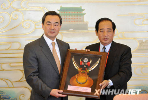 12月22日，王毅接受臺灣少數民族代表人士訪問團贈送的禮品。