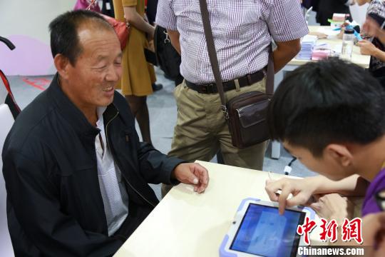 圖為當地市民接受血糖檢測 臺灣名品博覽會組委會提供 攝