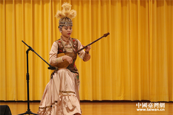 薩克族女孩高薩爾�努爾勒汗彈奏民族樂器“冬不拉”。