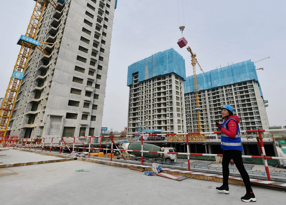 3月8日，在西安市未央區一處建設工地，中建三局西北公司一名女工在指揮塔吊作業。