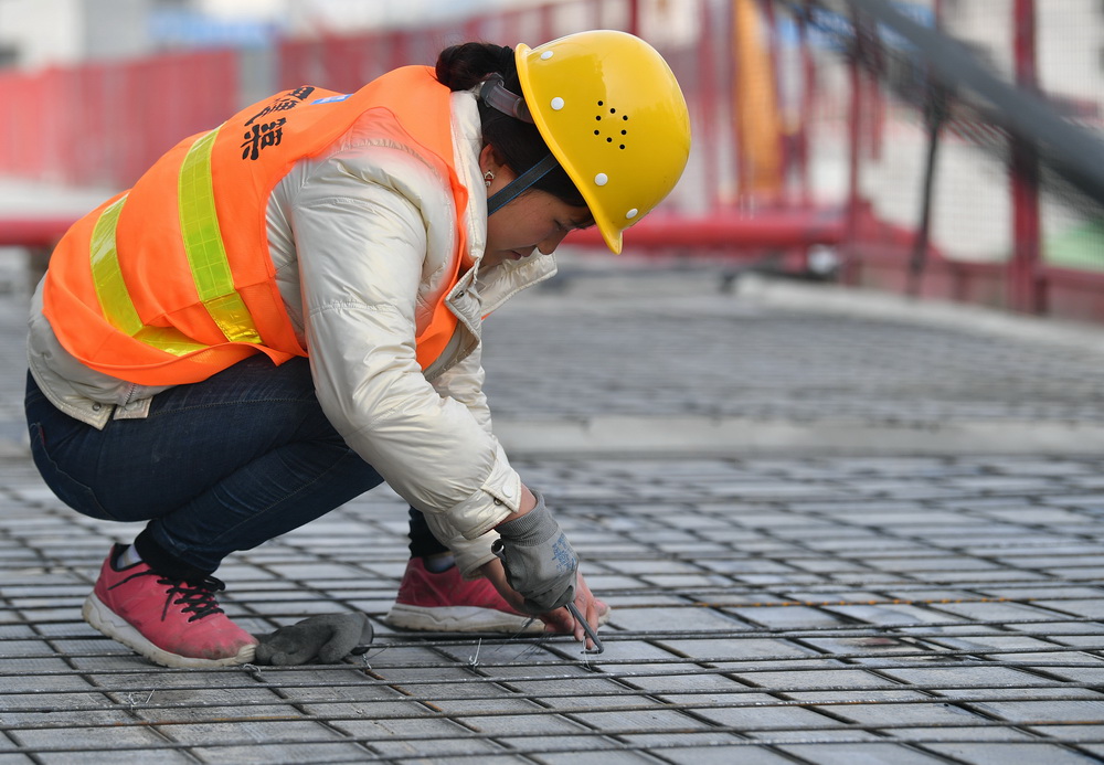3月8日，在西安市未央區一處建設工地，中建三局西北公司一名女工在捆紮鋼筋。