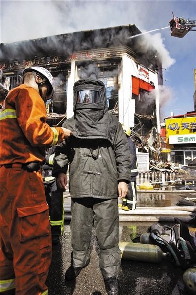昨日，消防戰士穿著隔熱服裝準備進入商場滅火。
