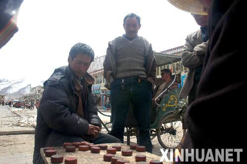  4月3日，人們在阿壩縣城街邊下象棋。 當日，四川省阿壩藏族羌族自治州阿壩縣天空晴朗，人們紛紛走出家門享受愜意的陽光。目前，發生“3�16”打砸搶燒暴力犯罪事件的阿壩縣，已恢復正常的生産和生活秩序。