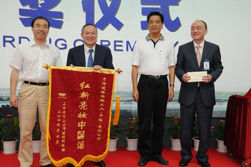 上海世博局副局長丁浩(左)向亨特道格拉斯公司頒授錦旗。
